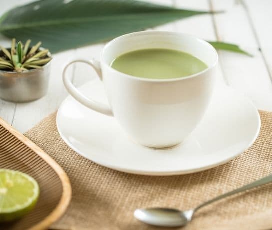 Hot matcha in a ceramic bowl with traditional matcha tools